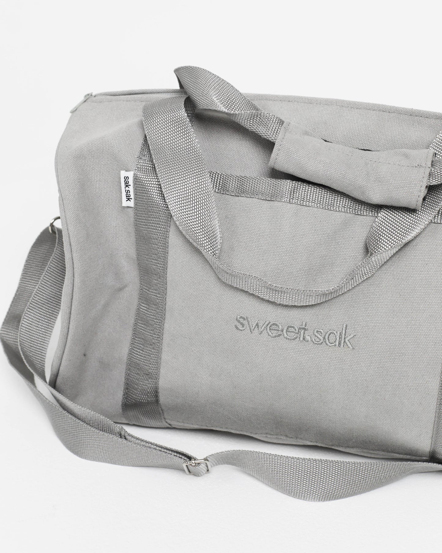 Gray duffel bag with 'sweetsak' branding on a white background