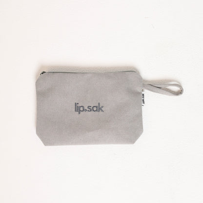 Gray pouch with 'lip.sak' branding on a white background