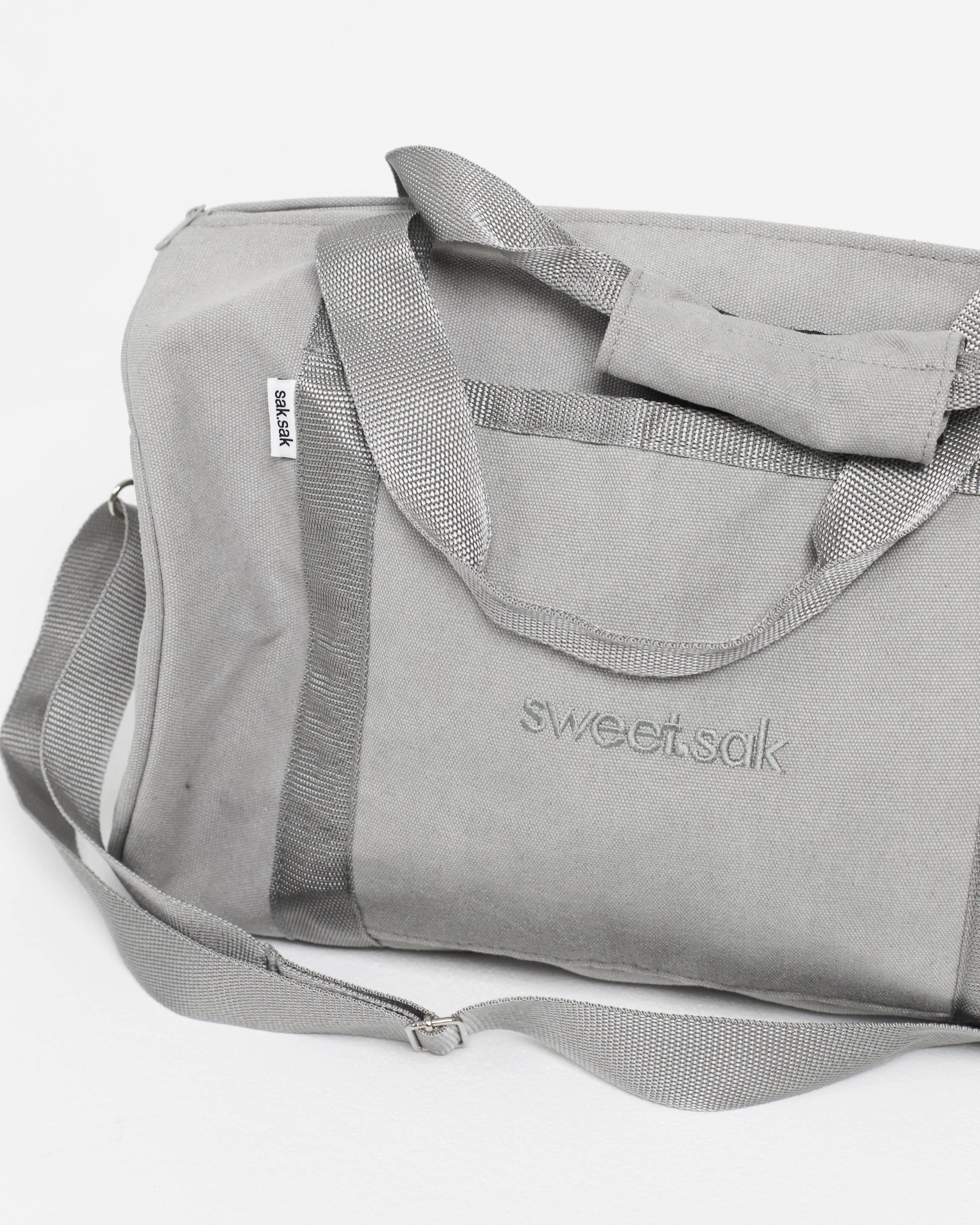 Gray duffel bag with 'sweetsak' branding on a white background